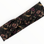 Papillon de Lune Stirnband von Doggies Couture mit elegantem Schmetterlings-, Blumen- und Mond-Design in Rosa, Lila, Gold und Petrol auf schwarzem Hintergrund, aus weichem Jersey mit stylischem Twistknoten.