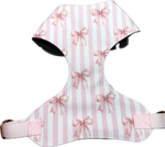 Vollbrustgeschirr 2.0 „Wrapped in Blush“ von Doggies Couture in zartem Rosa mit romantischem Schleifenmuster. Handgefertigtes Hundegeschirr mit extra Polsterung zur Druckentlastung am Brustkorb, zwei D-Ringen und zwei frostsicheren Klickverschlüssen gegen Verrutschen des Rückenteils. Verstellbares Hundegeschirr für Komfort, Sicherheit und stilvolle Spaziergänge.