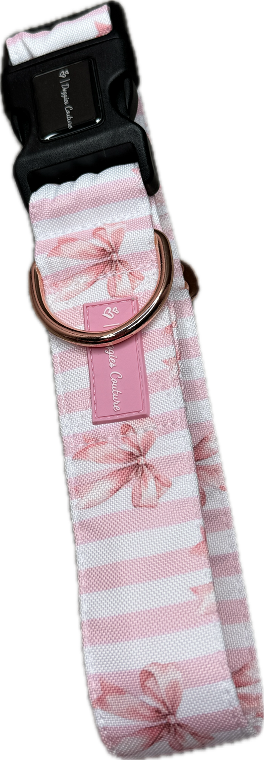 Halsband „Wrapped in Blush“ von Doggies Couture in zartem Rosa mit romantischem Schleifenmuster. Handgefertigtes Hundehalsband mit frostsicherem Klickverschluss und stabilem D-Ring zur Befestigung der Leine. Erhältlich in den Größen S bis XL sowie den Breiten 30 mm, 40 mm und 50 mm. Stilvolles, pflegeleichtes Hundehalsband für Alltag, Training und besondere Momente. 🎀🐾🤍