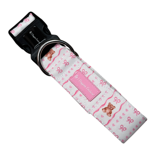 Handgefertigtes Hundehalsband „Tied in Softness“ mit zartem rosa Schleifen-, Herz- und Teddy-Motiv. Das stilvolle Halsband verfügt über einen stabilen D-Ring zum Befestigen der Leine sowie einen frostsicheren Klickverschluss für sicheren Halt. Erhältlich in den Größen S–XL und den Breiten 30 mm, 40 mm und 50 mm. Auf Wunsch auch maßgeschneidert in individuellen Größen und Breiten. Pflegeleicht und waschbar im Wäschebeutel in der Waschmaschine.