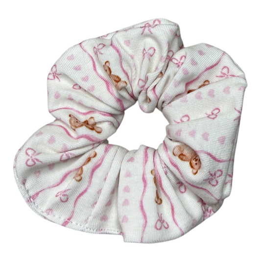 Handgefertigtes Scrunchy „Tied in Softness“ aus weichem Jersey mit rosa Schleifen-, Herz- und Teddy-Motiv. Das stylische Haaraccessoire ist besonders weich, dehnbar und angenehm zu tragen. Schonend zum Haar, ohne Ziehen, Abbrechen oder Verheddern. Liebevoll verarbeitet für hohen Tragekomfort und lange Haltbarkeit. Perfekt für Alltag, Sport und besondere Momente. One Size.