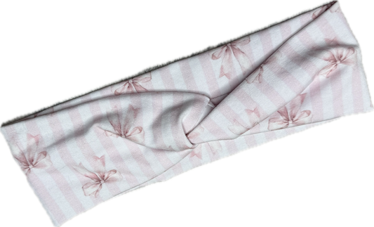 Stirnband „Wrapped in Blush“ von Doggies Couture in zartem Rosa mit romantischem Schleifenmuster. Handgefertigtes Stirnband aus weichem Jersey mit stylischem Twist in der Mitte. Angenehm zu tragen, rutschfest und schonend zum Haar – perfekt für Alltag, Spaziergänge, Hundesport und den abgestimmten Matching-Look von Hund und Mensch. 🎀🤍✨